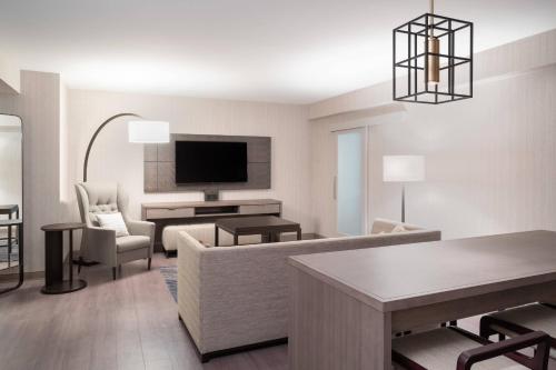 a living room with a couch and a tv at Mystic Marriott Hotel and Spa in Groton