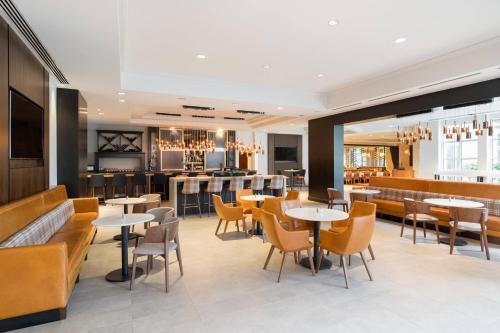 a restaurant with tables and chairs and a bar at Mystic Marriott Hotel and Spa in Groton
