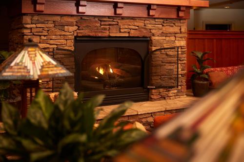 a stone fireplace with a fire in it at Avila Village Inn in Avila Beach
