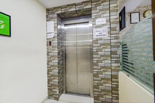 a metal elevator in a building with a brick wall at SIRI Tals Hitech in Hyderabad