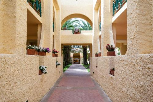 an alley with potted plants on the walls of a building at Mangia's Brucoli, Sicily, Autograph Collection in Brucoli