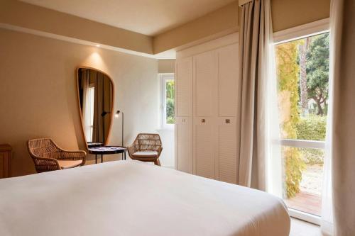 a bedroom with a large white bed and a window at Mangia's Brucoli, Sicily, Autograph Collection in Brucoli