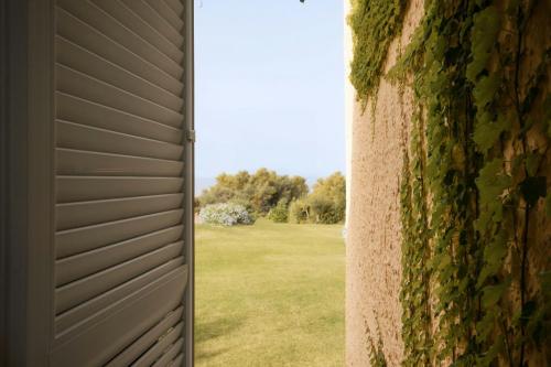 a door leading into a yard with a field behind it at Mangia's Brucoli, Sicily, Autograph Collection in Brucoli