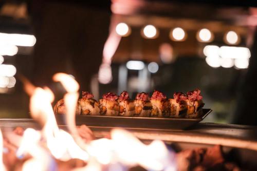 a tray of food cooking on a grill at Mangia's Brucoli, Sicily, Autograph Collection in Brucoli