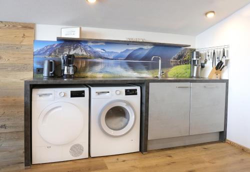 a laundry room with a washing machine and a sink at Hörlbauer-Leogang in Leogang
