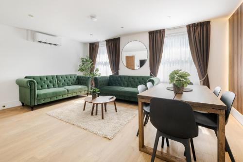 Una sala de estar con un sofá verde y una mesa. en Luxury Apartment in Marylebone, en Londres