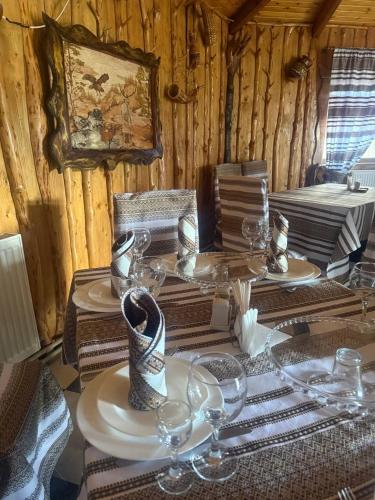 a table with plates and wine glasses on it at Sadyba Pidkova Чан сауна Приймаємо групи до 70людей in Pistyn