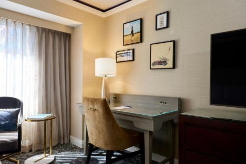 a hotel room with a desk and a television at The Henry, Autograph Collection in Dearborn