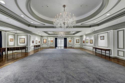 an empty ballroom with a chandelier and a large room at The Henry, Autograph Collection in Dearborn