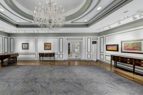 an empty room with a piano and a chandelier at The Henry, Autograph Collection in Dearborn