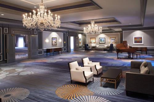 a lobby with chandeliers and a grand piano at The Henry, Autograph Collection in Dearborn