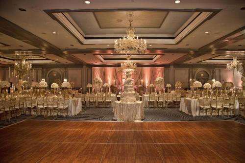 a banquet hall with tables and chairs and a chandelier at The Henry, Autograph Collection in Dearborn