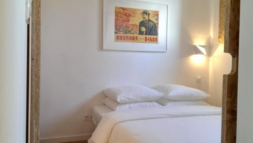 a bedroom with a bed with a poster on the wall at Shiro - Appartement 2beapart in Lyon