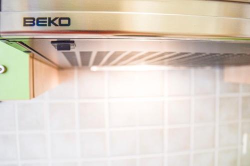 a stove top oven in a kitchen with white tiles at Apartment Ennio in Povlja