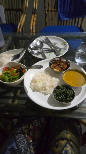 a plate of food with rice and vegetables on a table at Prafulla Homestay in Kārwār