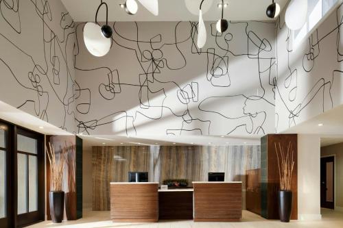 a lobby with a wall with drawings on the ceiling at Courtyard by Marriott Los Angeles Pasadena Old Town in Pasadena