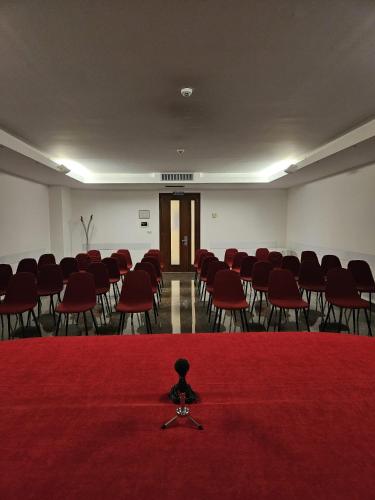a room filled with red chairs and a red carpet at Appia Antica Hotel in Corato