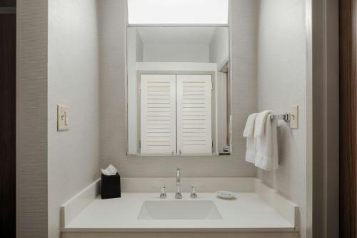 a white bathroom with a sink and a mirror at Courtyard Dayton South Mall in Miamisburg
