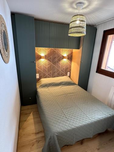 une petite chambre avec un lit dans une pièce dans l'établissement Appart T2 Cosy vue panoramique Lac & Montagnes, aux Angles