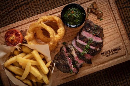 a wooden tray with a steak and french fries and onion rings at Sheraton Jumeirah Beach Resort in Dubai
