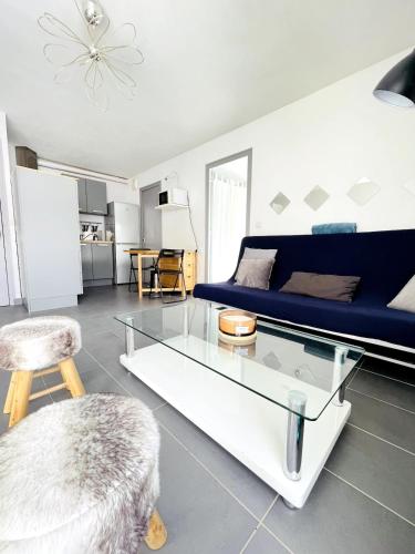 un salon avec un canapé bleu et une table en verre dans l'établissement La Vouagère - mountain view, aux Gets