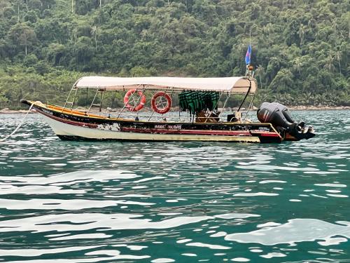 a boat with a cover on the water at Mama's Chalet Pulau Perhentian Besar in Perhentian Island
