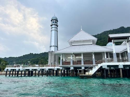 a lighthouse on a pier on the water at Mama's Chalet Pulau Perhentian Besar in Perhentian Island