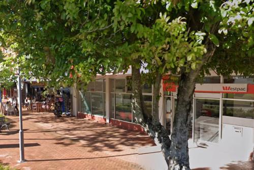 a building on a street with trees in front of it at Ocean Retreat in Yeppoon