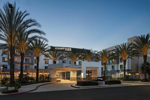 a hotel with palm trees in front of a building at Courtyard Long Beach Airport in Long Beach