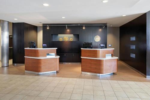 a lobby with two reception desks and a clock on the wall at Courtyard Long Beach Airport in Long Beach