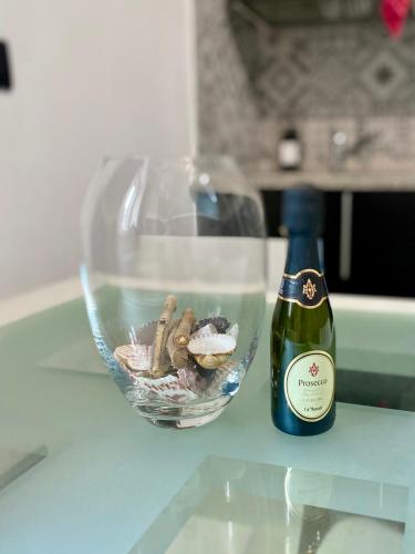 a bottle of wine next to a glass bowl of oysters at Lemon tree 400 mt dal mare in Nettuno