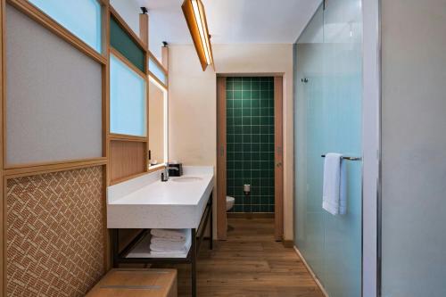 a bathroom with a sink and a shower at Aloft Playa del Carmen in Playa del Carmen
