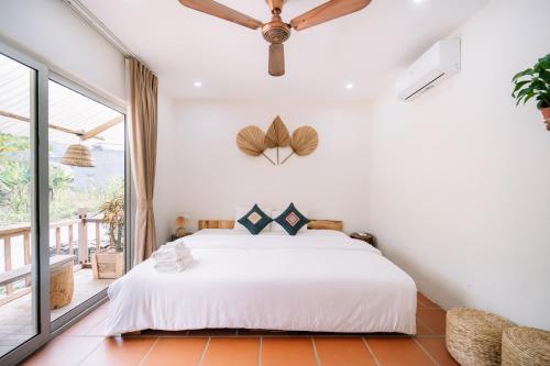 a bedroom with a bed and a large window at Anans Home Ha Giang - Tours & Motorbike Rental in Ha Giang