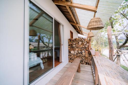 a porch with a bench and a stack of fire wood at Anans Home Ha Giang - Tours & Motorbike Rental in Ha Giang