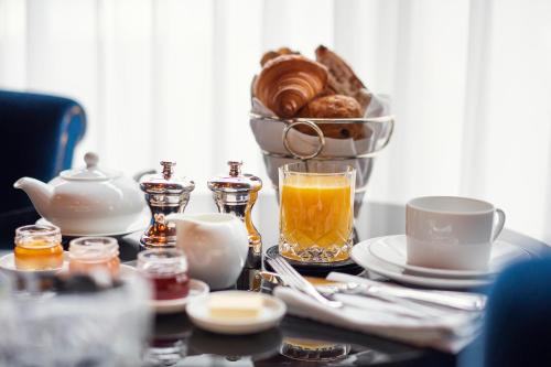 a table with a cup of tea and a basket of bread at Maison Souquet, Hotel & Spa in Paris