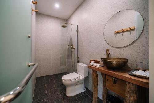 a bathroom with a sink and a toilet and a mirror at Anans Home Ha Giang - Tours & Motorbike Rental in Ha Giang