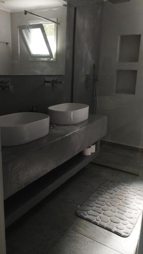 a bathroom with two sinks and a mirror and a tub at Villa Neli I in Achlia