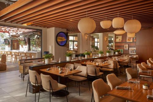 a restaurant with wooden tables and chairs and lights at Hilton San Diego Gaslamp Quarter in San Diego