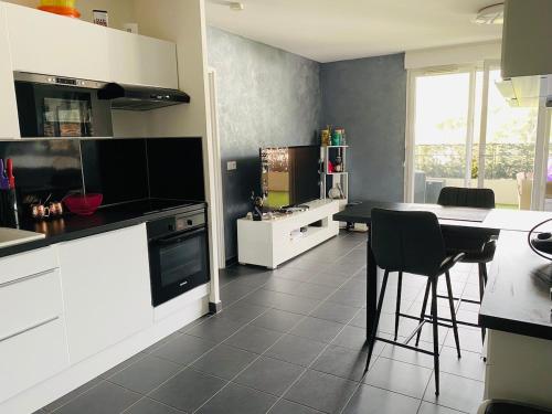 une cuisine avec des armoires blanches et une table et des chaises dans l'établissement T2 proche calanque sormiou, à Marseille