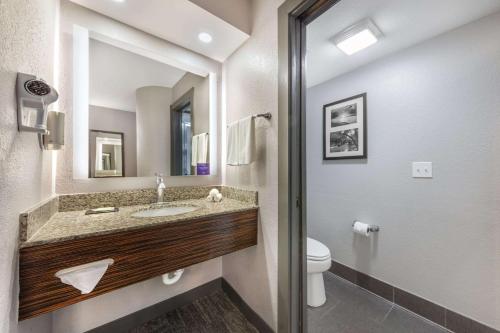 a bathroom with a sink and a toilet and a mirror at Sleep Inn Miami Airport in Miami