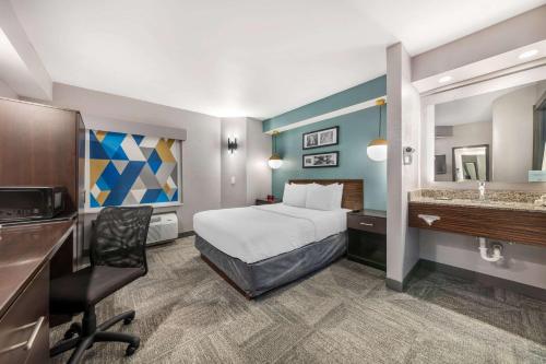 a hotel room with a bed and a desk at Sleep Inn Miami Airport in Miami