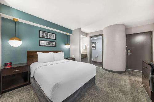 a hotel room with a large bed and a bathroom at Sleep Inn Miami Airport in Miami