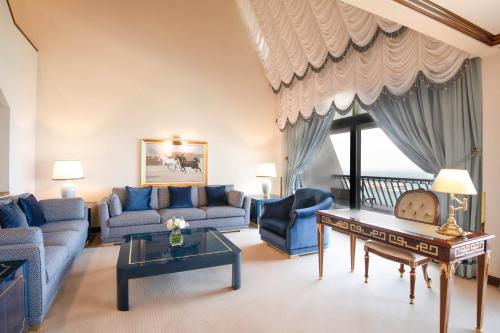 a living room with a couch and a table at Sheraton Grand Doha Resort & Convention Hotel in Doha
