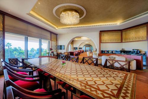 a dining room with a long table and chairs at Sheraton Grand Doha Resort & Convention Hotel in Doha