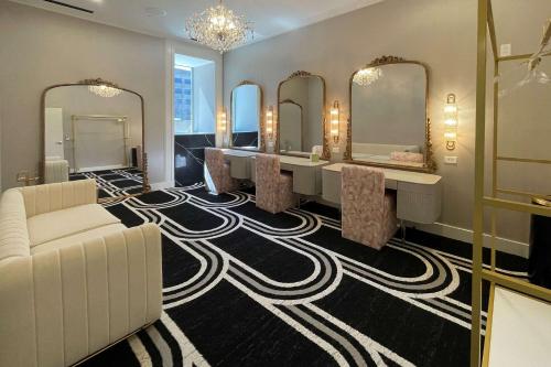 a dressing room with mirrors and a long table with chairs at Cambria Hotel Detroit Downtown in Detroit