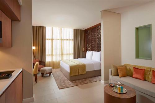 a hotel room with a bed and a couch at Tilal Riyadh in Riyadh