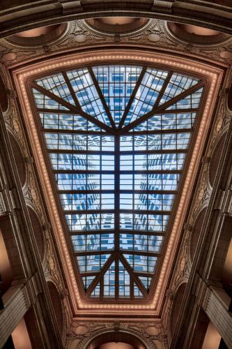 a ceiling of a building with a large glass window at Hotel David Whitney, Autograph Collection in Detroit