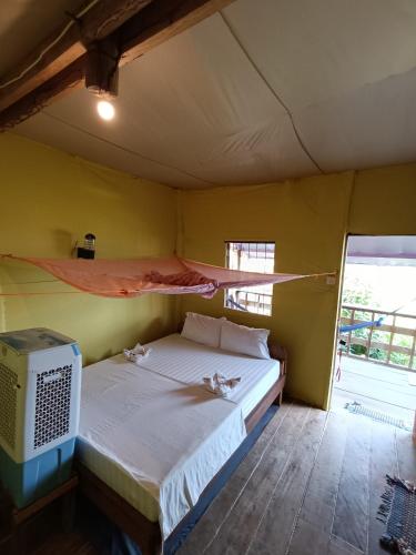 a bedroom with a bed with a hammock on it at Kohrong Sea Views Bungalows in Koh Rong Island