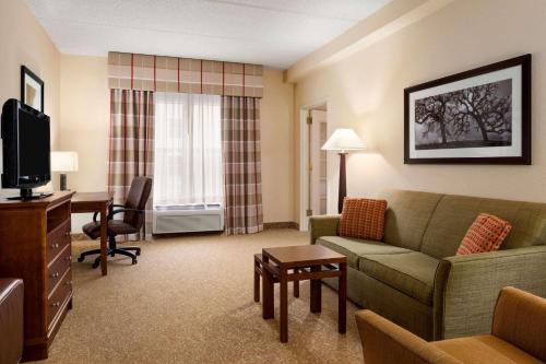 a living room with a couch and a desk and a television at Country Inn & Suites by Radisson, Anderson, SC in Anderson