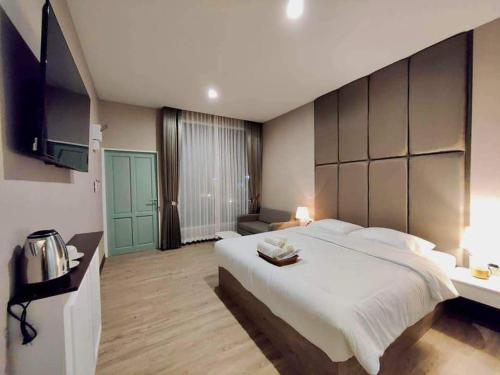 a large bedroom with a large bed and a television at Chergreen cafe & house in Ban Prong Phra Bat Nok